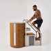 Man climbing wooden steps into a portable hot tub with 'Cicetubs' branding.