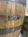 Close-up of a wooden barrel with metal bands and a latch.