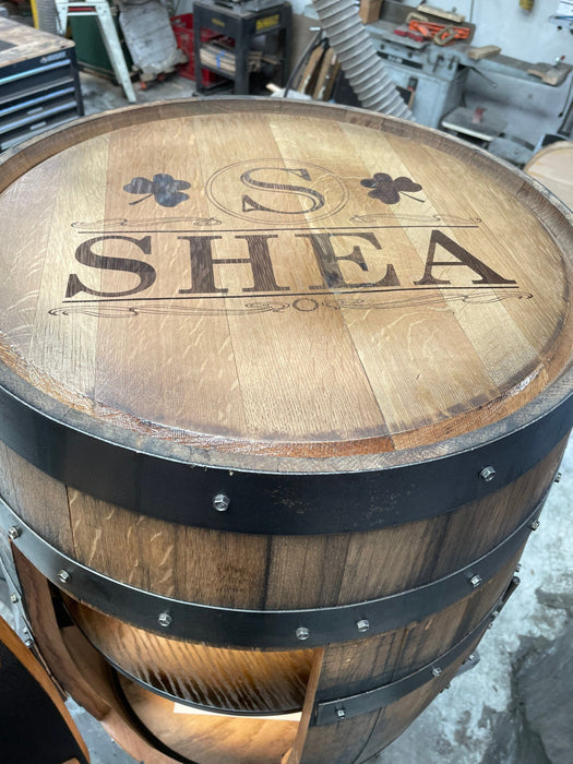 Wooden barrel with 'SHEA' engraved on it in a workshop setting