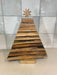 Wooden Christmas tree decoration with a star on top against a tiled wall background