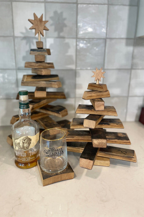 Wooden Christmas tree with a bottle and glass on a tiled floor