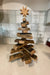 Wooden Christmas tree with a star on top against a tiled wall.