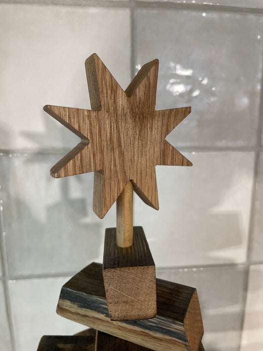 Wooden star-shaped object on a stand against a light background