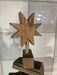 Wooden star-shaped object on a stand against a light background
