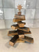 Wooden Christmas tree with star topper on a reflective surface