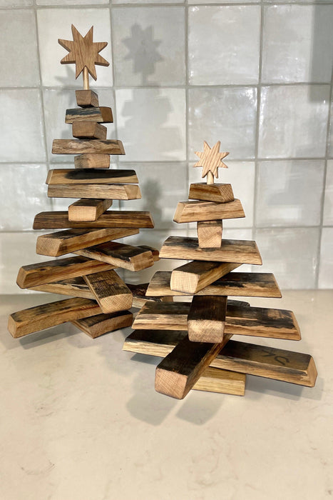 Wooden Christmas tree with star toppers on a tiled floor
