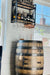 Wooden barrel bar with hanging shelf and glasses indoors