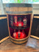 Wooden barrel-shaped bar with liquor bottles inside, set against a neutral background.
