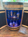 Wooden barrel with blue interior displaying various bottles of alcohol.