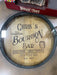 Personalized bourbon barrel head with engraved text on a wooden surface.