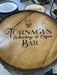 Wooden barrel with 'Turnage's Whiskey & Cigar Bar' engraving on a concrete floor.