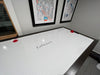 Air hockey table with 'LaFrance' branding in a room with framed artwork on the wall.