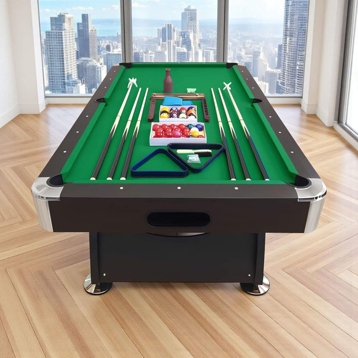 Pool table with accessories in a room with large windows showing a cityscape.