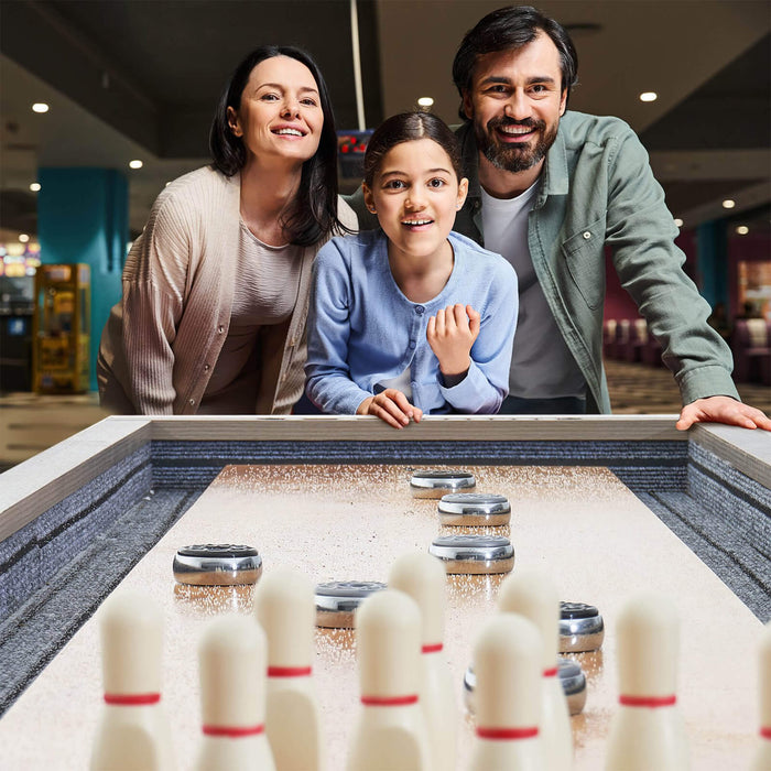 Family of three posing in front of a bowling alley.