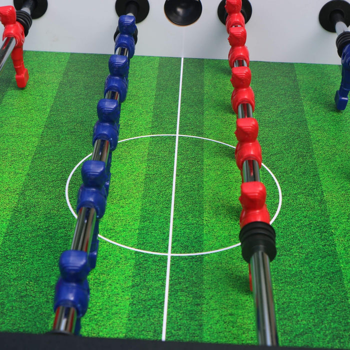 Close-up of table football rods with red and blue ends on a green playing field.