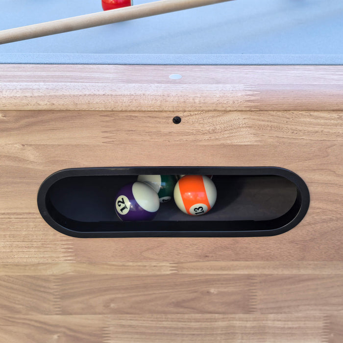 Pool balls in a pocket on a wooden pool table