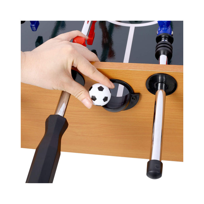Hand placing a soccer ball into a foosball table