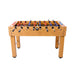 Wooden foosball table with red, blue, and black player figures on a white background