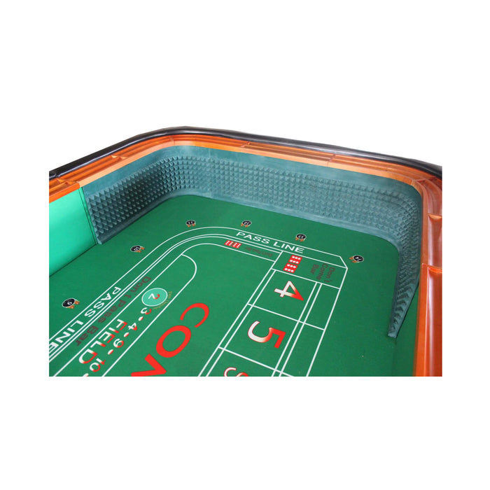 Close-up of a craps table with green felt and red and black markings.