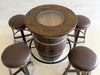 Wooden barrel table with four bar stools on a tiled floor.