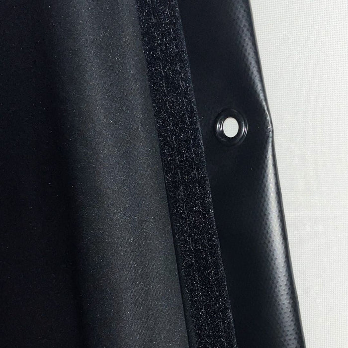Close-up of a black car door panel with a button on a white background