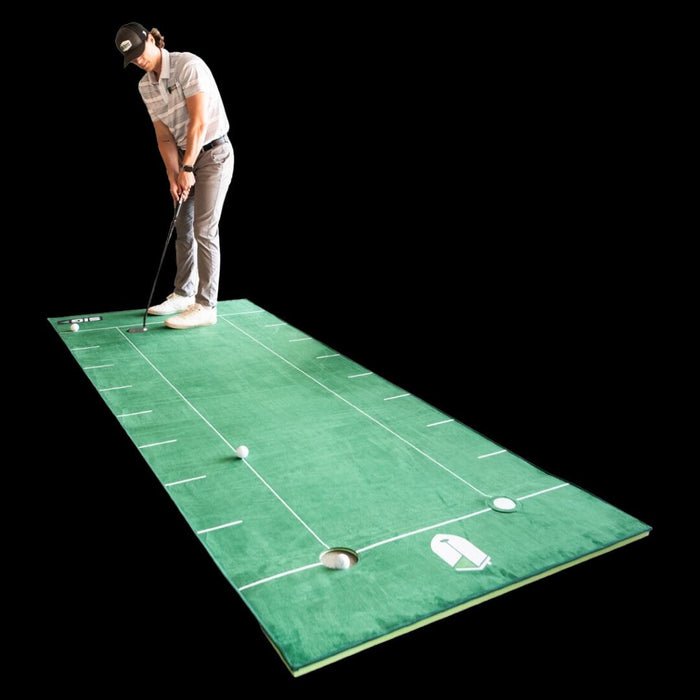 Person practicing golf swings on a green mat with white lines and balls.