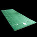 Golf practice mat with green surface and white lines on a black background