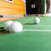 Golf balls on a green surface with a blurred background