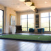 Indoor putting green with chairs and large windows in the background
