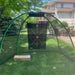 Golf practice net with a target board on a grassy area outdoors.