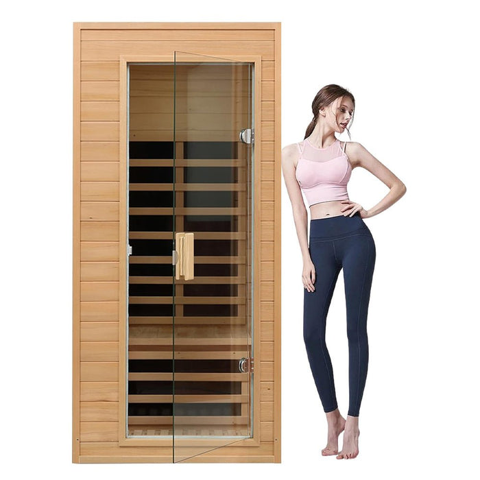 Woman standing next to a wooden sauna with glass door on a white background