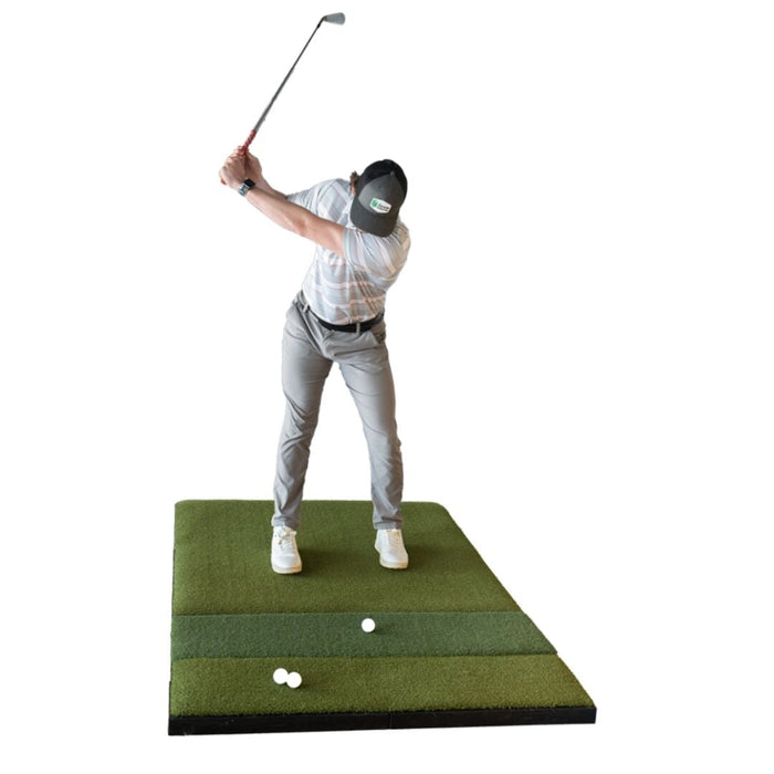 Person practicing golf swings on a green mat with a white background