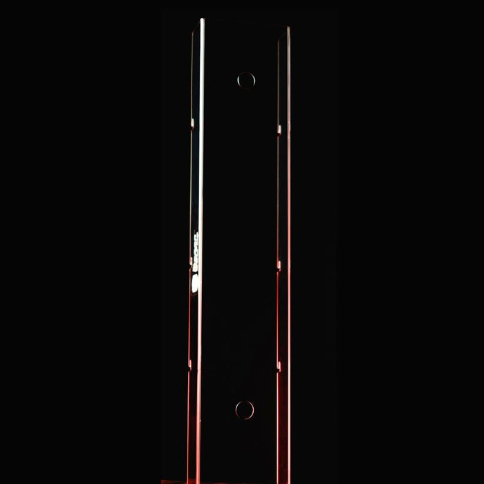 Tall, thin metallic object with a reflective surface on a black background