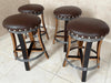 Four brown bar stools with metal legs on a tiled floor.
