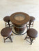 Wooden barrel table with four stools on a tiled floor.