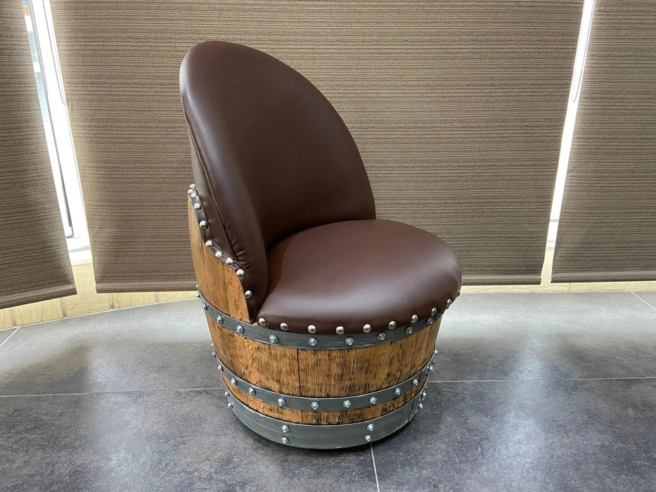 Chair made from a wine barrel with brown leather seats against a neutral wall.