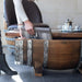 Wooden barrel with metal accents on a floor, person partially visible
