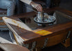 Person using a coffee press on a wooden table with a blurred background