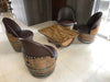 Wooden barrel chairs with a matching table on a tiled floor.