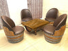 Wooden table with four barrel-style chairs in a room with decorative curtains.